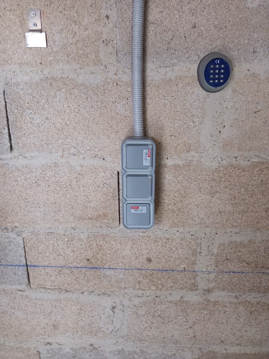 Boîtiers étanches Legrand Plexo neufs posés en saillie sur le mur en parpaing d'un garage à Thoiry, dans les Yvelines